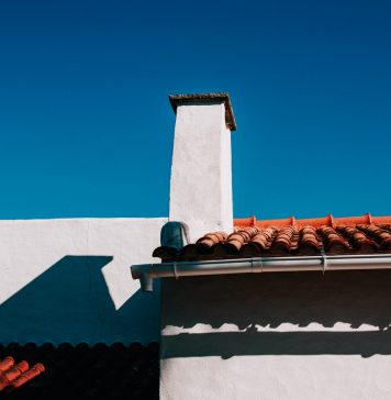 Sådan fungerer en professionel tagrenderensning Flot orange tag ovenpå hvid bygning