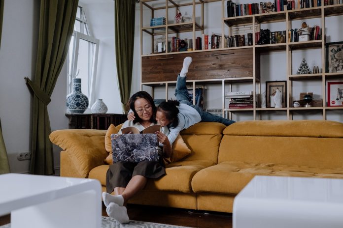 Kvinde sidder i sofa med et barn