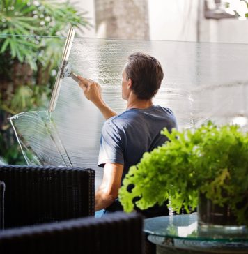 Spar tid, og få en vinduespudser til at klare vinduerne for dig Mand pudser vinduer i gård
